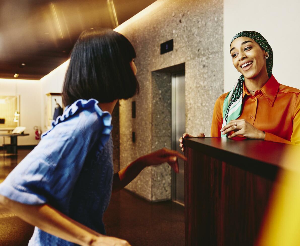 Smiling hotel receptionist helping a guest. Smiling hotel receptionist helping a guest.
