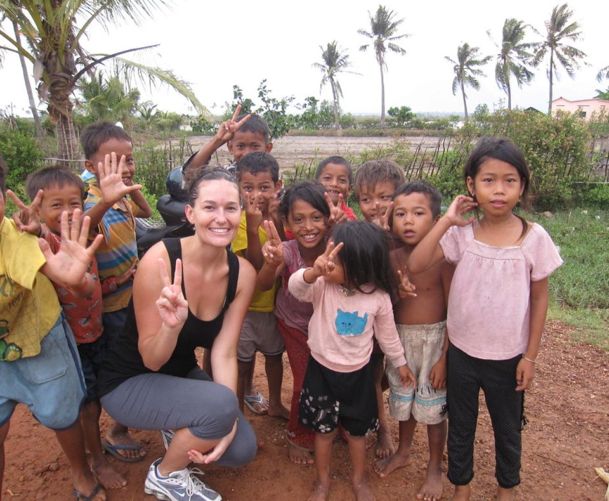 smiling woman surrounded by children smiling woman surrounded by children